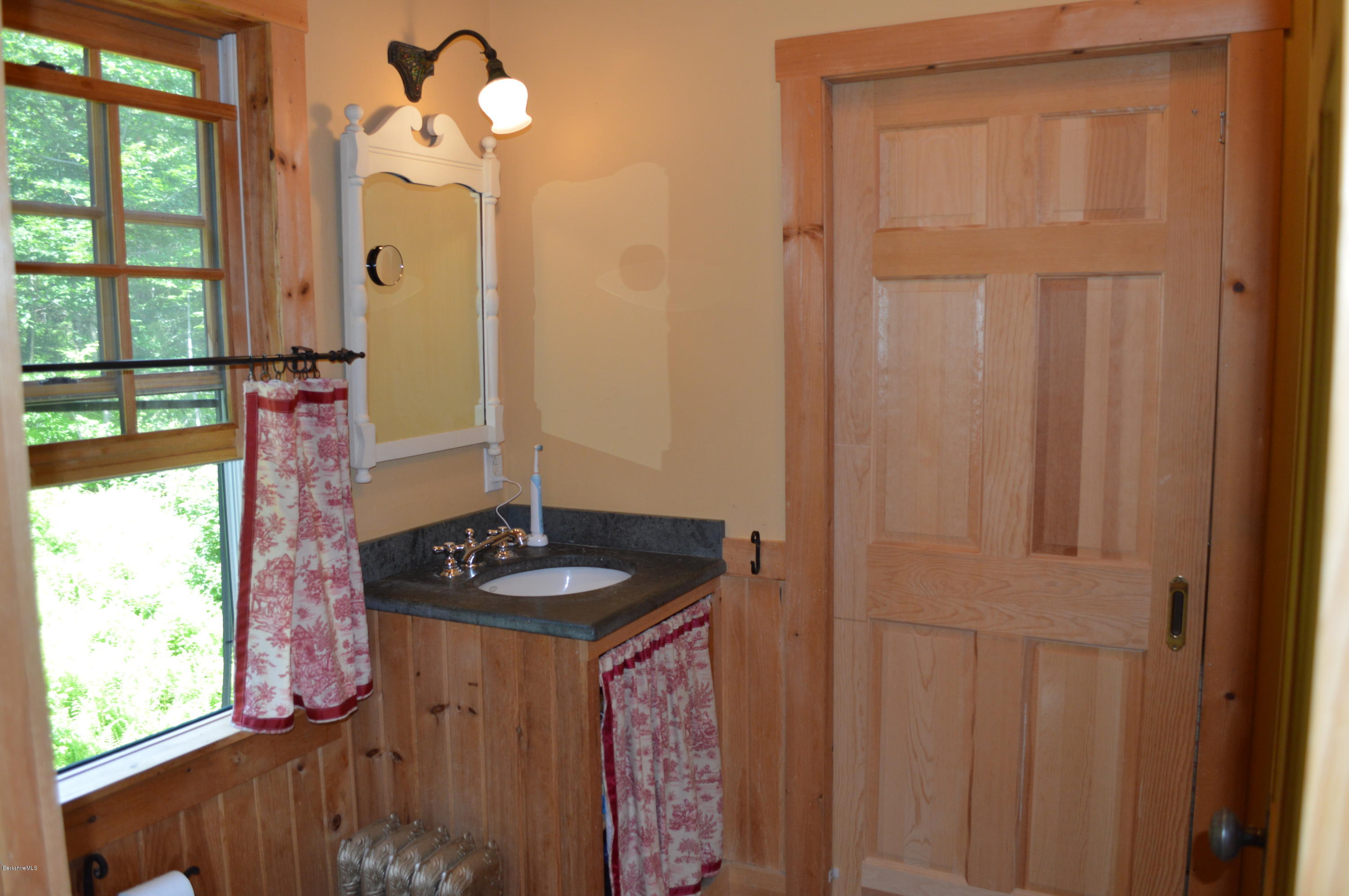 1297 Fred Snow Road Becket, MA 01223 - Photo 27 of 41 a bathroom with a granite countertop sink and a mirror