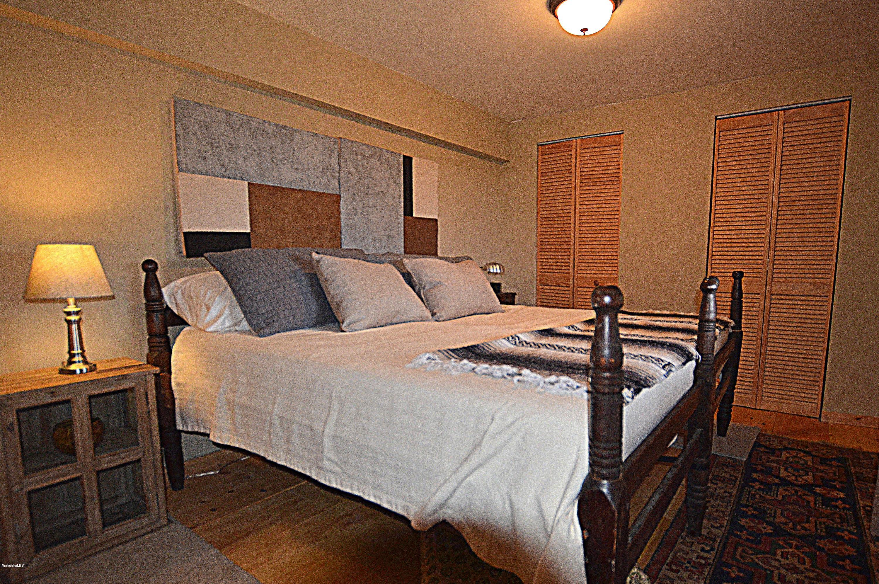 1297 Fred Snow Road Becket, MA 01223 - Photo 34 of 41 a bedroom with a bed and a lamp