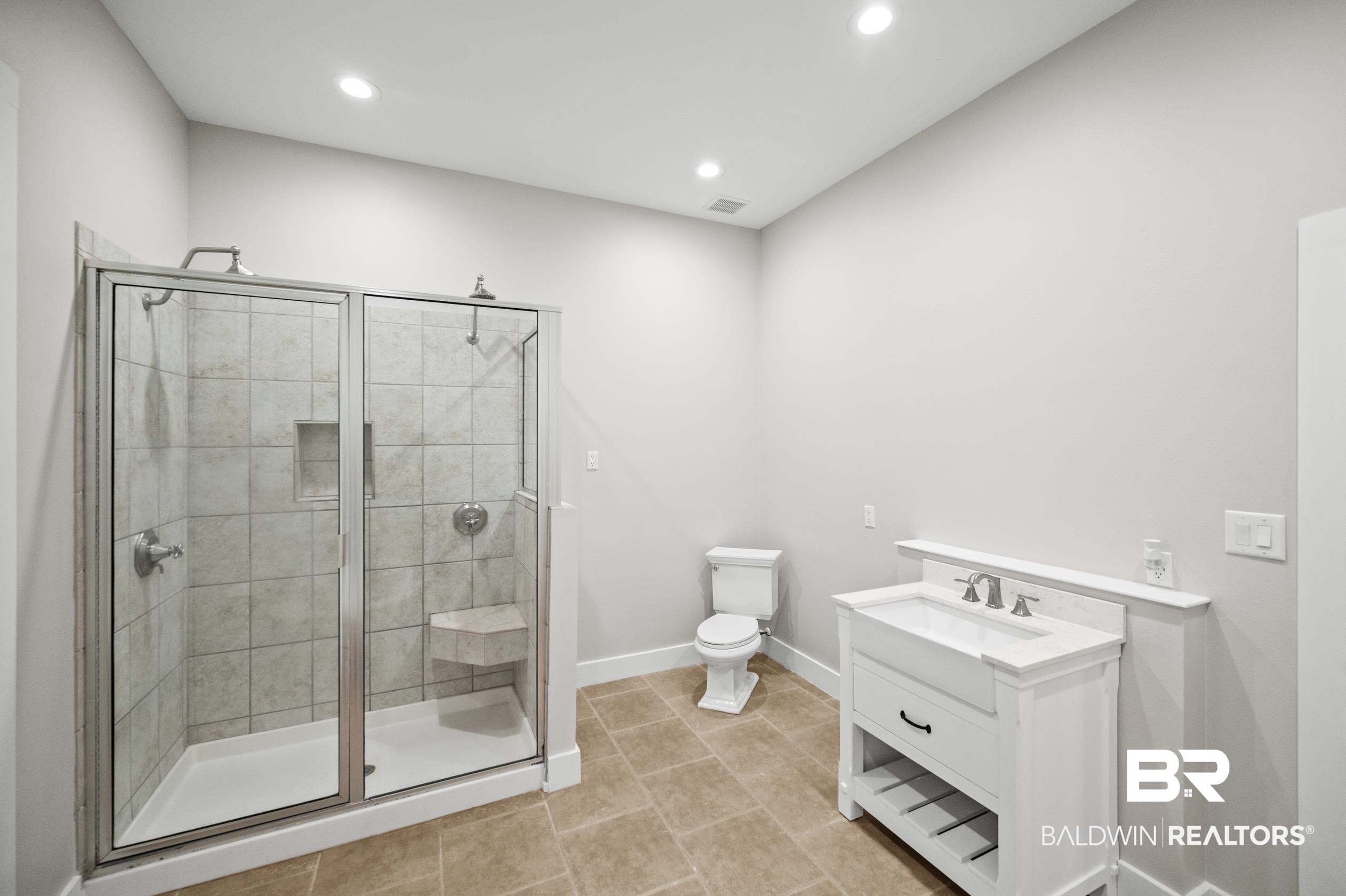 15031 Timber Ridge Drive Loxley, AL 36551 - Photo 22 of 43 Bathroom featuring tile patterned flooring, toilet, vanity, and an enclosed shower