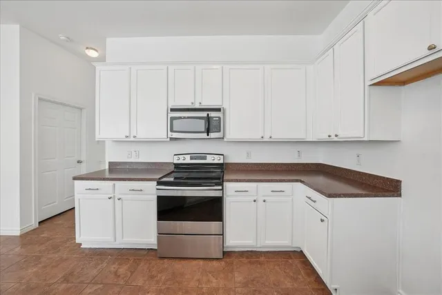 a kitchen with stainless steel appliances granite countertop a stove a sink and a microwave