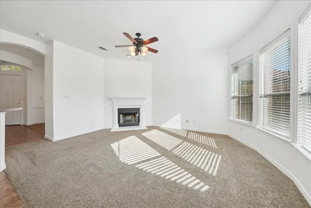 a view of an empty room with a window and fireplace