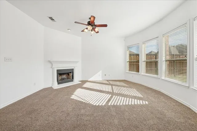 a view of an empty room with a fireplace and a window