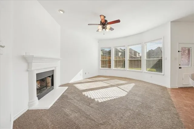 a view of an empty room with a fireplace and a window