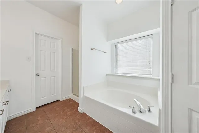 a bathroom with a bathtub and a window