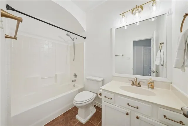 a bathroom with a bathtub shower sink vanity mirror and toilet