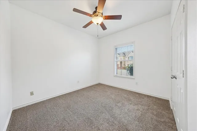 an empty room with fan and windows