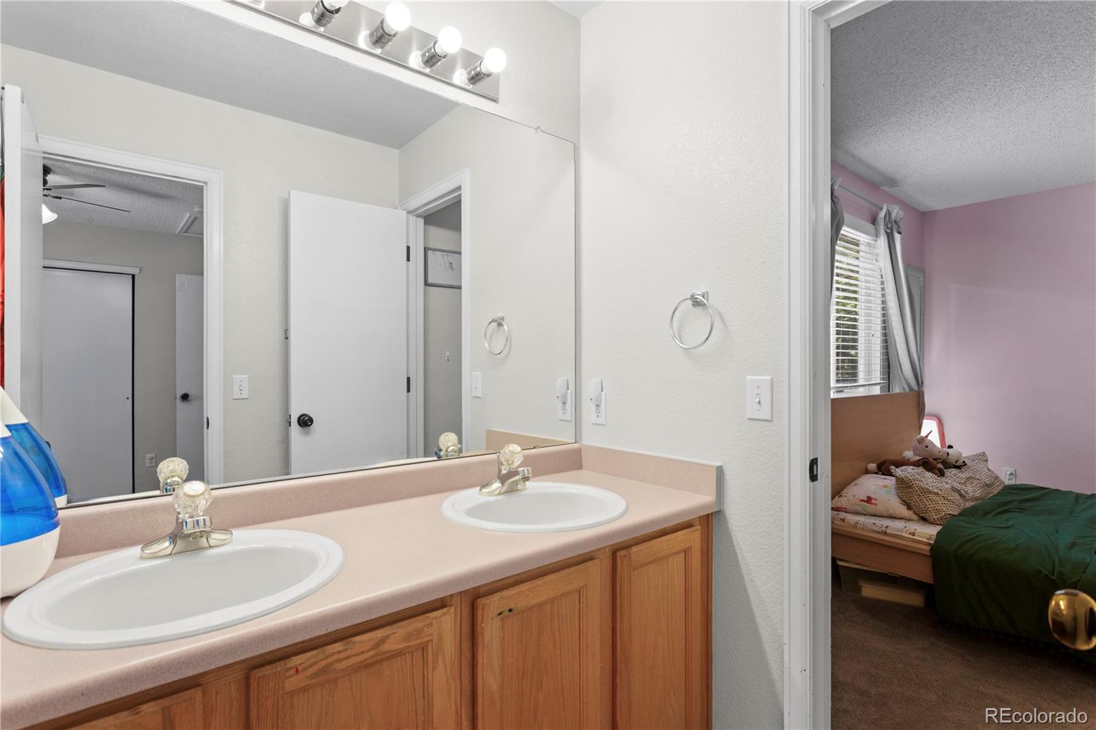 2212 Hyacinth Road Littleton, CO 80129 - Photo 27 of 44 a bathroom with a sink double vanity and a mirror