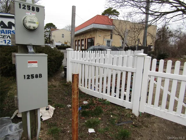 a view of a house with a small yard and wooden fence