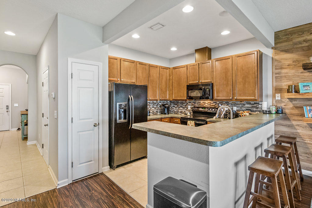 12940 Spring Rain Road Jacksonville, FL 32258 - Photo 5 of 20 a kitchen with refrigerator cabinets and wooden floor