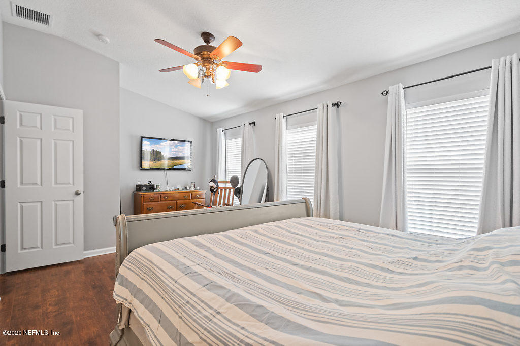 12940 Spring Rain Road Jacksonville, FL 32258 - Photo 9 of 20 a bedroom with a bed and a chandelier