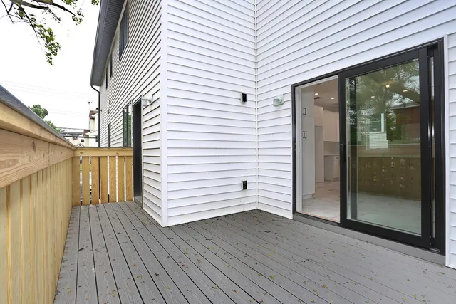 a view of a porch with wooden floor and floor to ceiling window