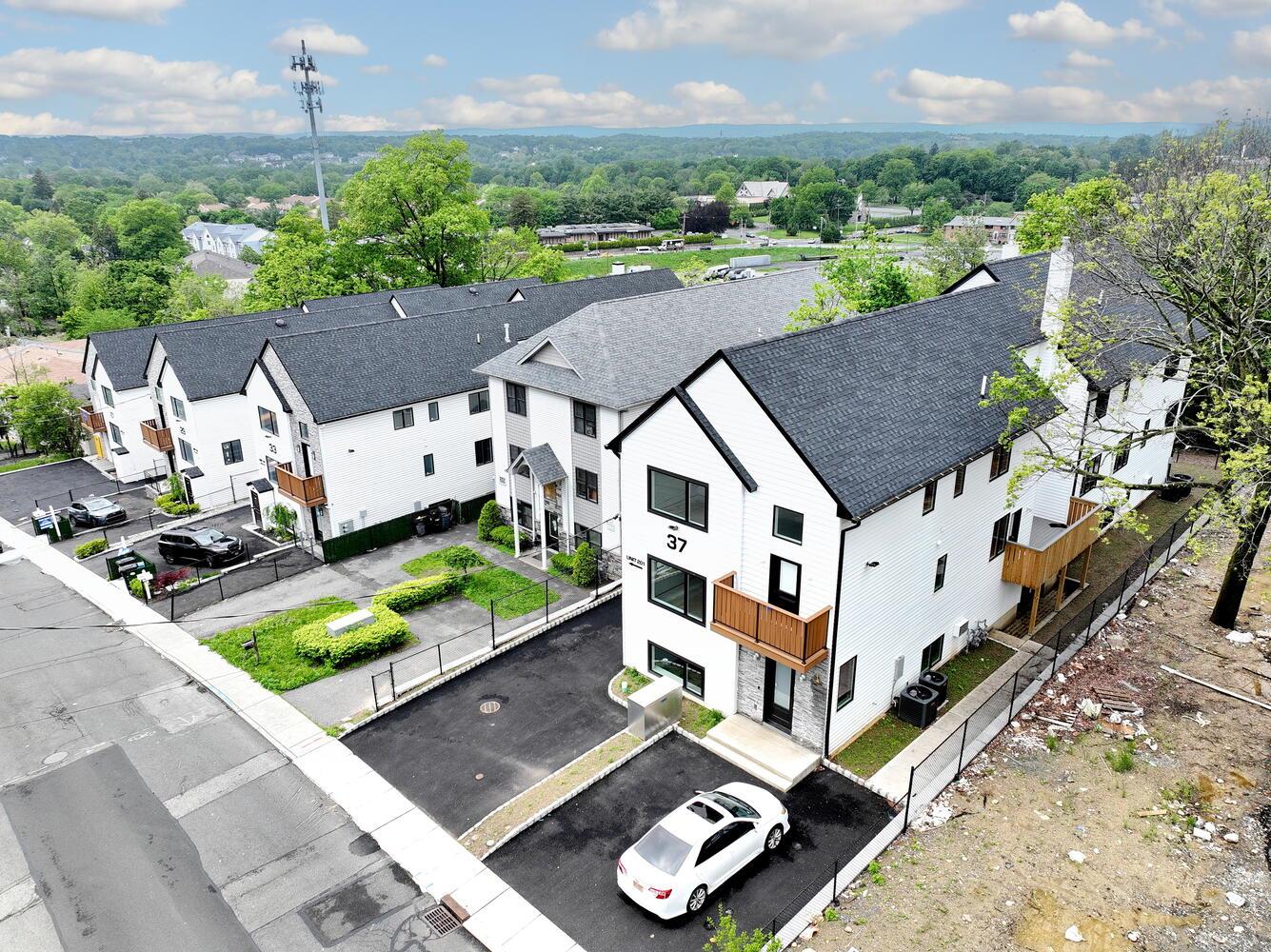 37 Ewing Avenue, Unit 202 Spring Valley, NY 10977 - Photo 3 of 44 an aerial view of a house with a garden and large trees