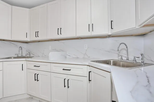a kitchen with white cabinets and a sink