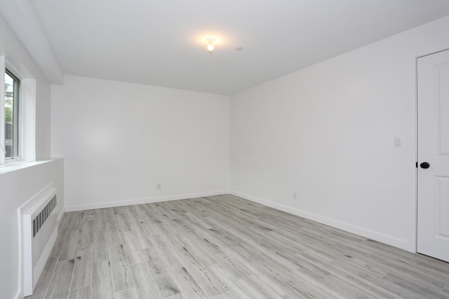 37 Ewing Avenue, Unit 202 Spring Valley, NY 10977 - Photo 38 of 44 an empty room with wooden floor and windows
