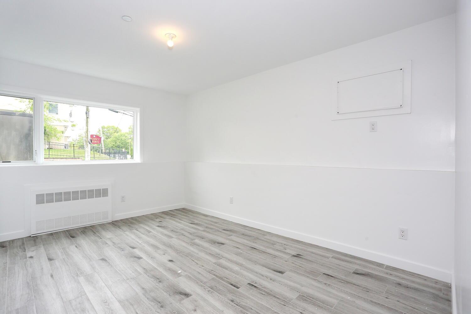 37 Ewing Avenue, Unit 202 Spring Valley, NY 10977 - Photo 40 of 44 an empty room with wooden floor and windows