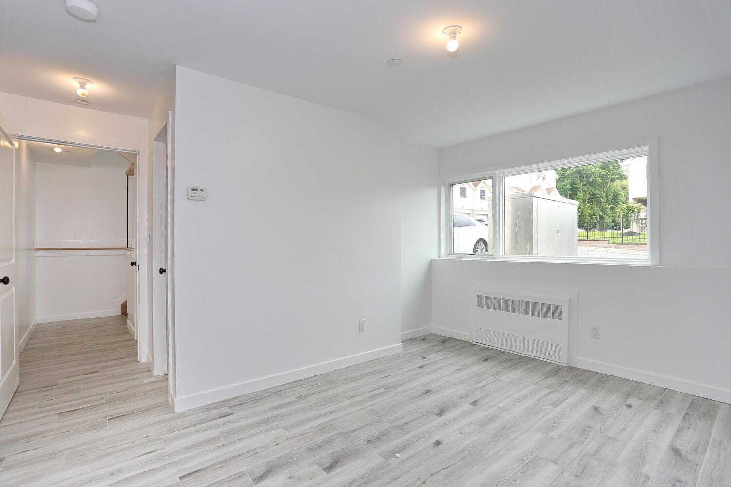 37 Ewing Avenue, Unit 202 Spring Valley, NY 10977 - Photo 41 of 44 an empty room with wooden floor and windows