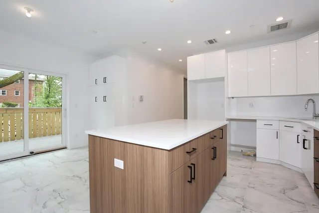 a kitchen with a stove a refrigerator a sink dishwasher with a dining table and chairs