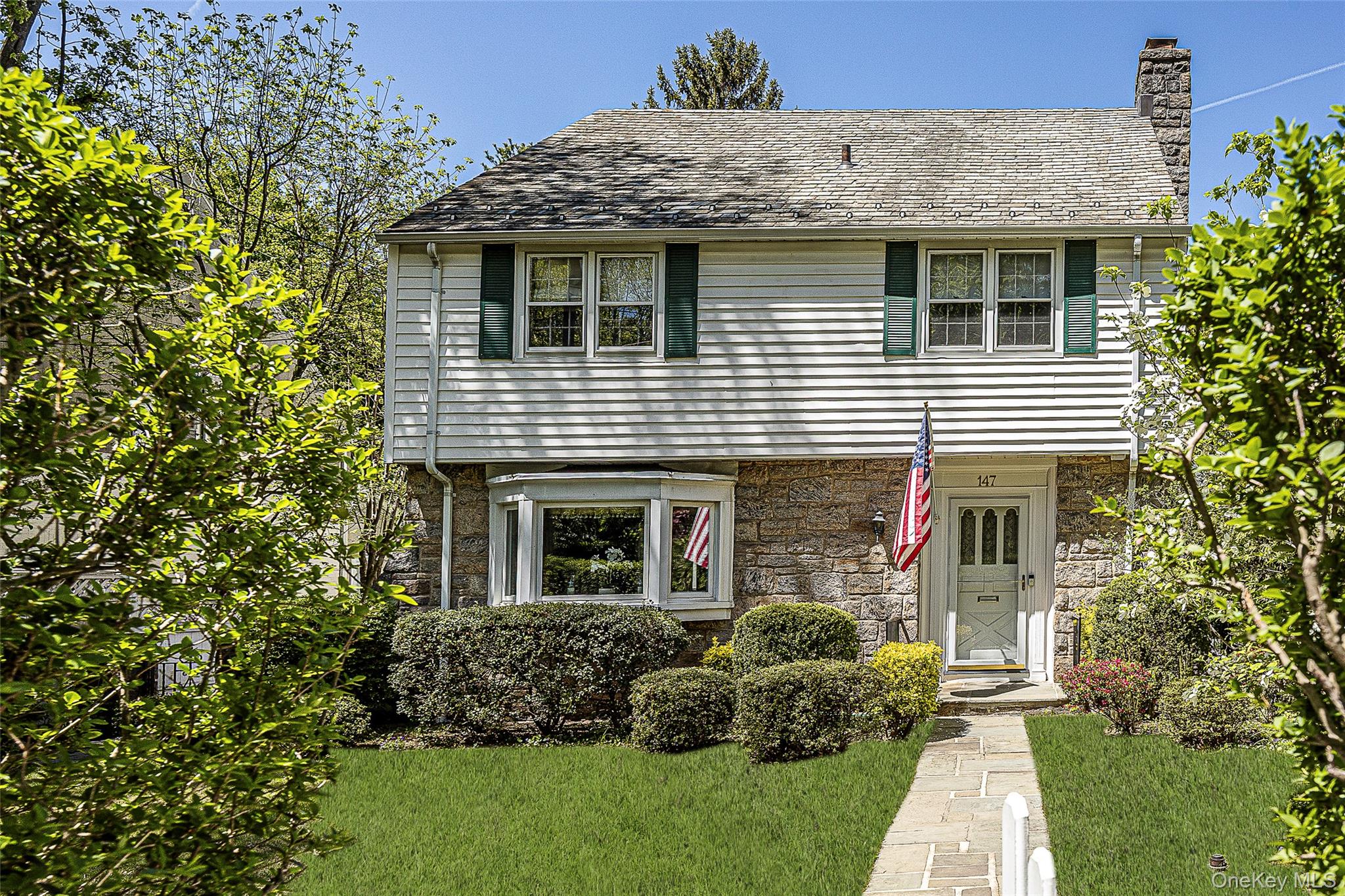 147 Midland Avenue Bronxville, NY 10708 - Photo 1 of 25 a view of a house with brick walls and a yard with plants