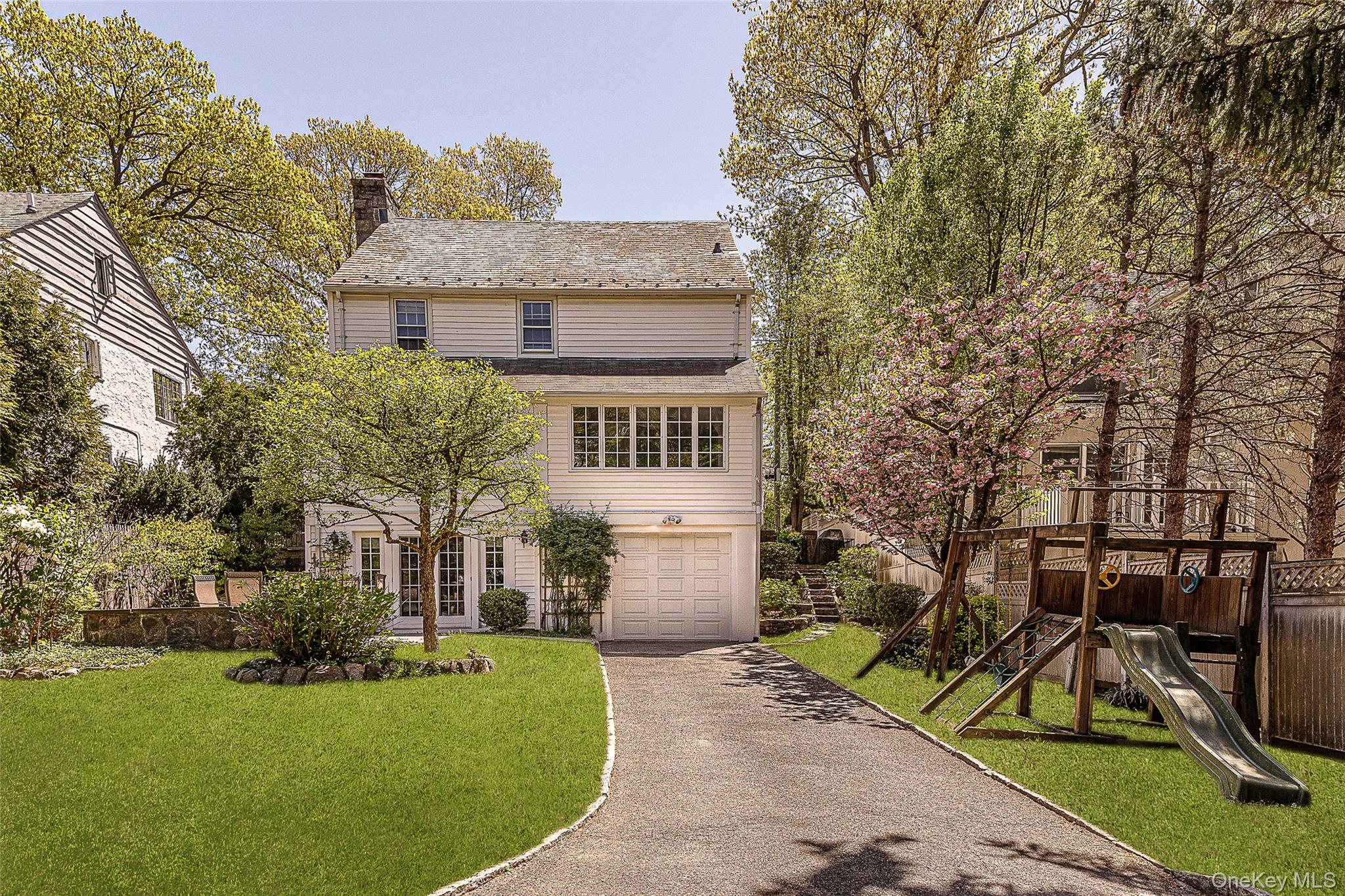 147 Midland Avenue Bronxville, NY 10708 - Photo 21 of 25 a front view of a house with a yard and trees