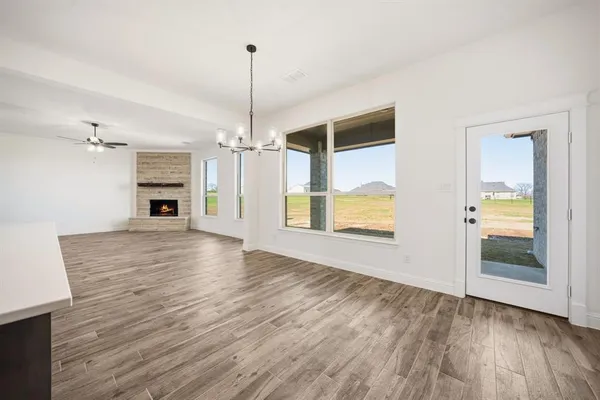 a view of empty room with wooden floor and window