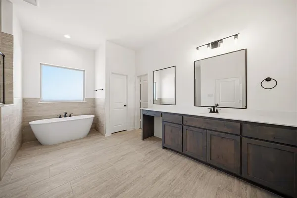 a bathroom with a sink a tub and mirror