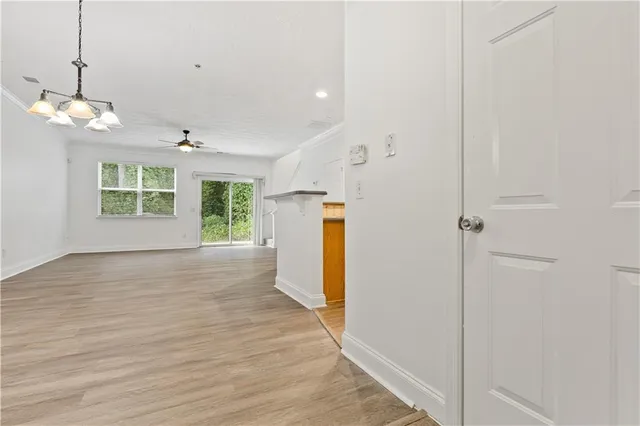 a view of empty room with wooden floor and windows
