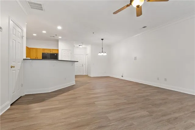 a view of empty room with wooden floor