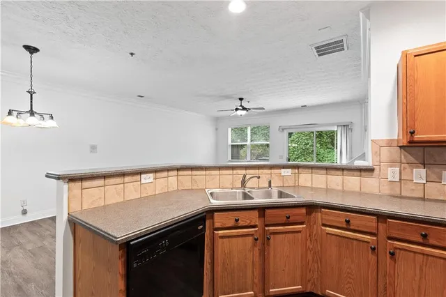 a kitchen that has a sink a window and cabinets