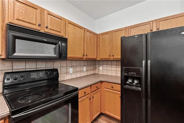 a kitchen with granite countertop a refrigerator stove and microwave