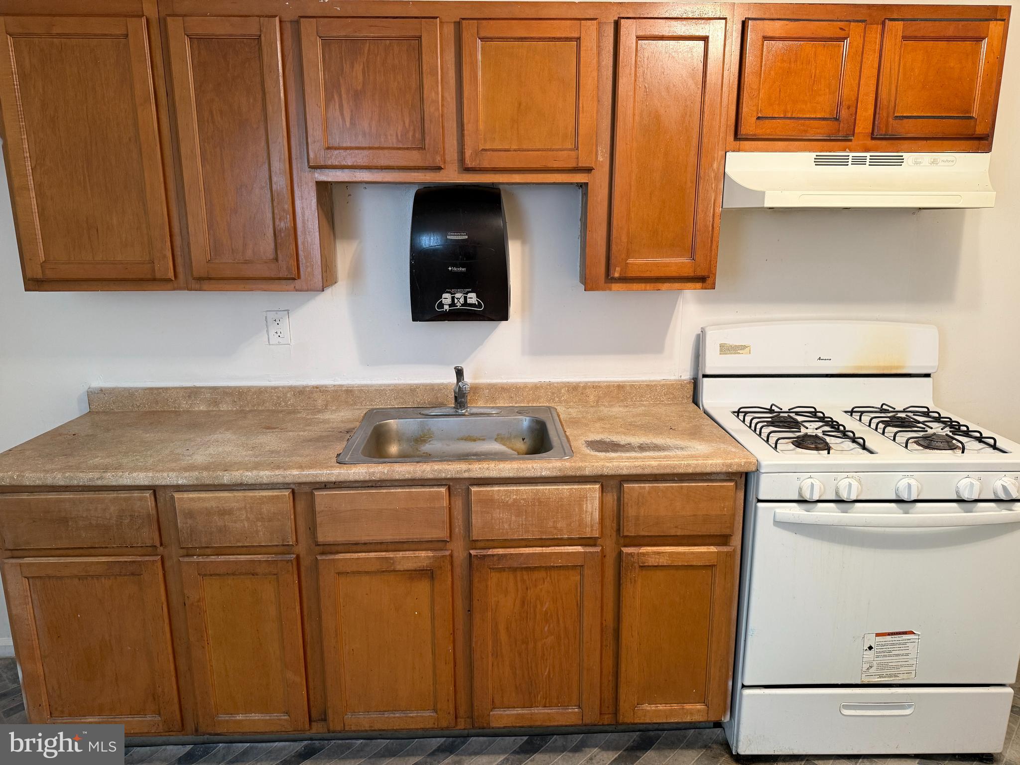 1016 Potter Street Chester, PA 19013 - Photo 7 of 22 a kitchen with kitchen island granite countertop wooden cabinets and white appliances