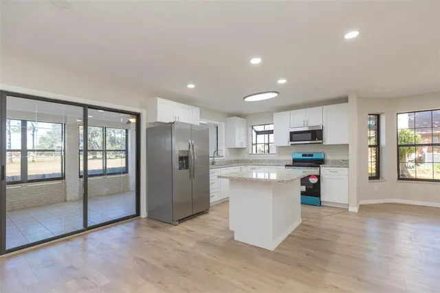 a kitchen with stainless steel appliances a refrigerator sink and microwave