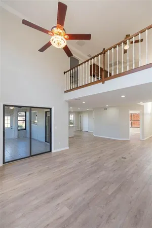 a view of an entryway wooden floor a chandelier fan and fire place