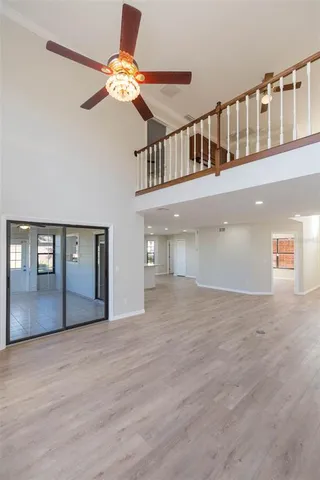 a view of an entryway wooden floor a chandelier fan and fire place