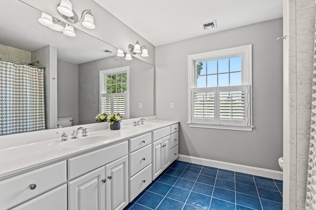17 Crown Ridge Road Wellesley, MA 02482 - Photo 24 of 37 a spacious bathroom with a double vanity sink a large mirror and a bathtub