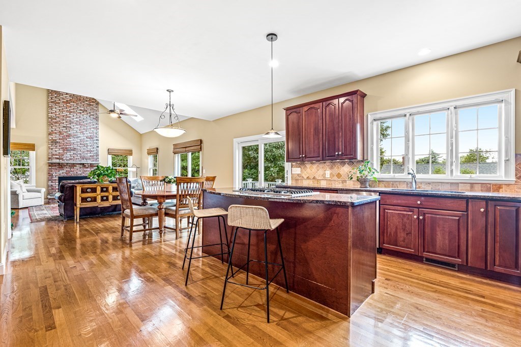 17 Crown Ridge Road Wellesley, MA 02482 - Photo 8 of 37 a kitchen with stainless steel appliances granite countertop wooden cabinets a dining table and chairs