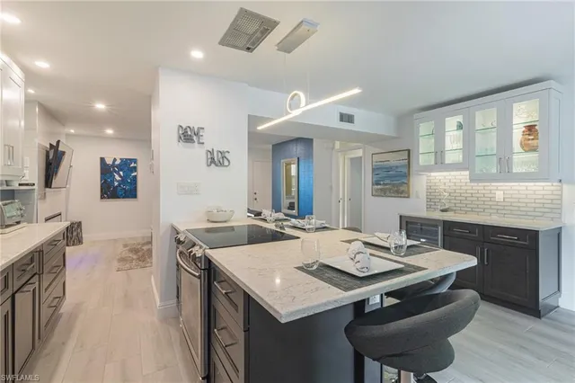 a kitchen with a stove a sink dishwasher and a dining table with wooden floor