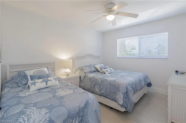 a bedroom with two beds and ceiling fan