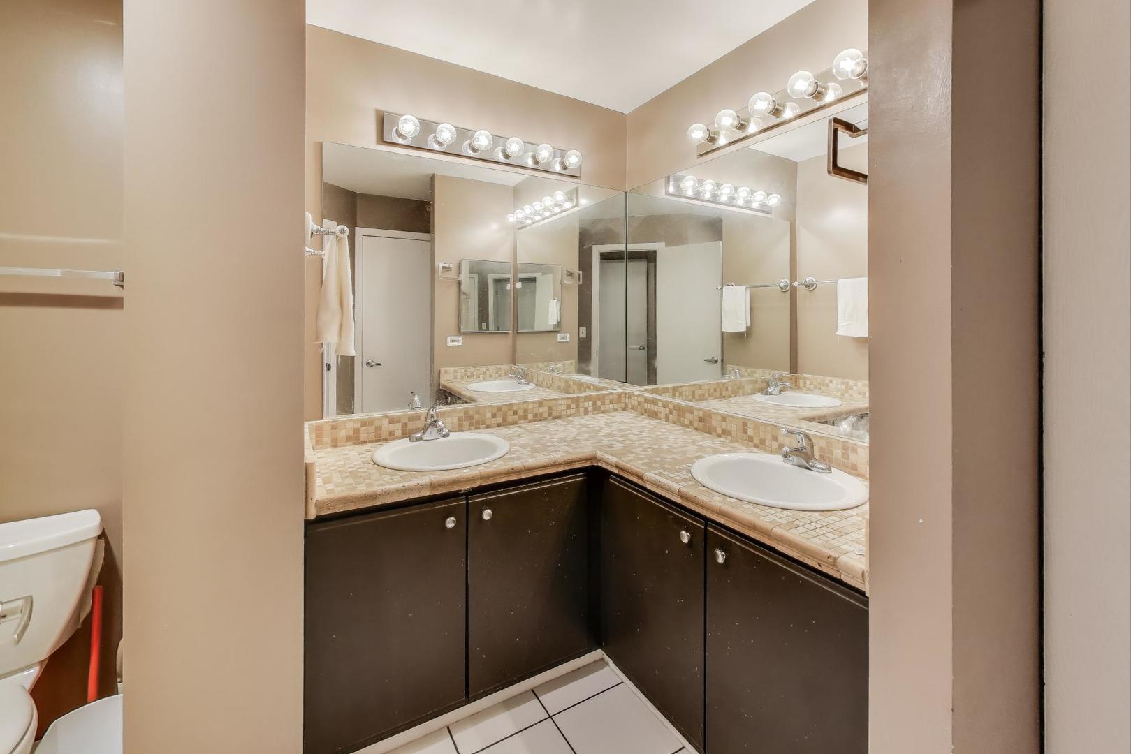 1905 Stillwater Road Arlington Heights, IL 60004 - Photo 22 of 36 a bathroom with a granite countertop sink a large mirror and a shower