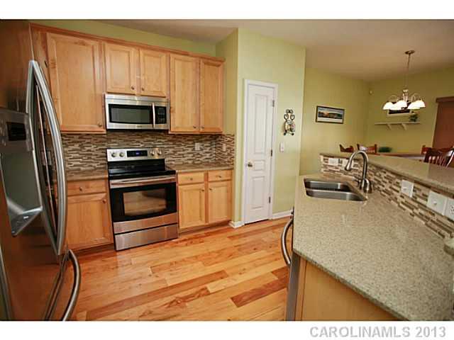 524 Bent Leaf Court Fort Mill, SC 29708 - Photo 7 of 16 a kitchen with stainless steel appliances a stove a sink a refrigerator white cabinets and wooden floor
