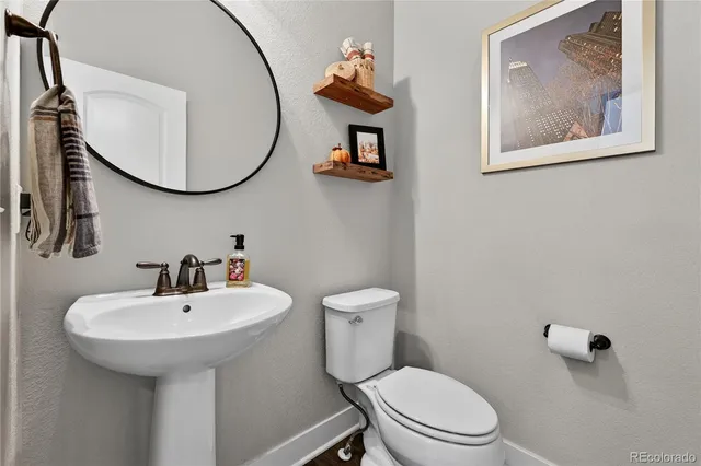 a bathroom with a toilet a sink and mirror