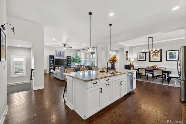 a large white kitchen with lots of counter space and stainless steel appliances