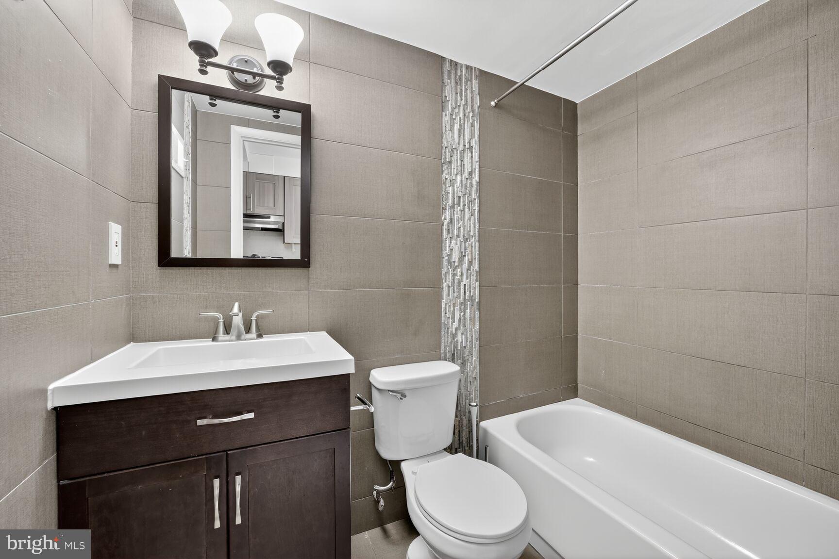 511 P Street Northwest, Unit 2 Washington, DC 20001 - Photo 12 of 15 a bathroom with a toilet a sink a mirror and vanity