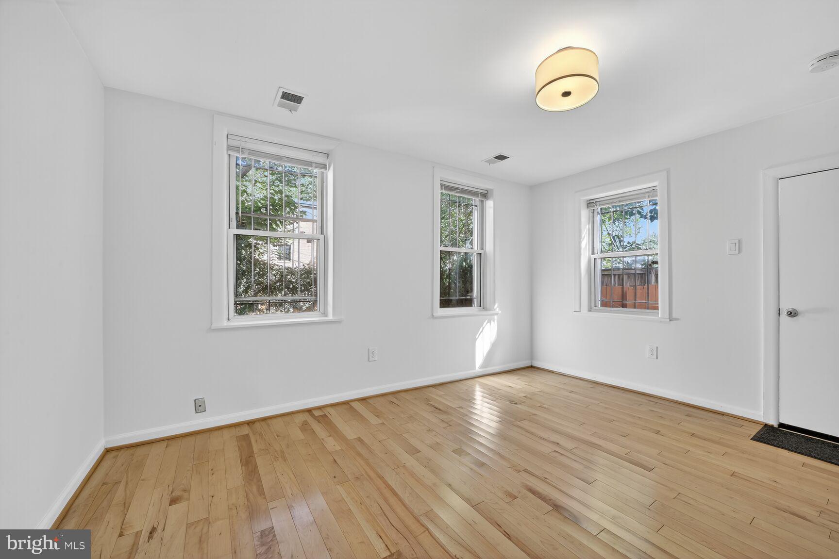 511 P Street Northwest, Unit 2 Washington, DC 20001 - Photo 8 of 15 a view of an empty room with wooden floor and a window