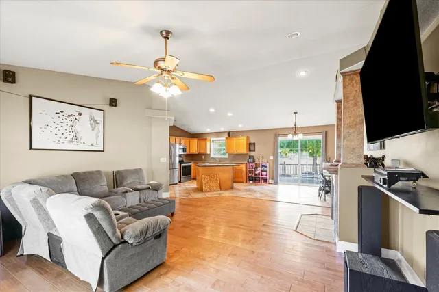 a living room with furniture a chandelier and a flat screen tv