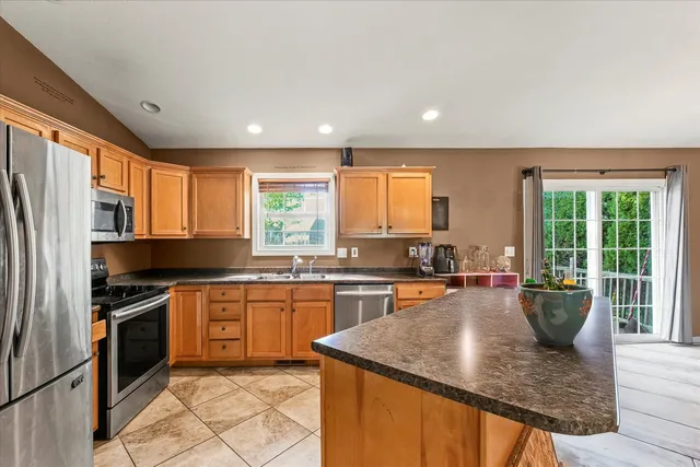 a kitchen with stainless steel appliances granite countertop sink stove top oven and cabinets
