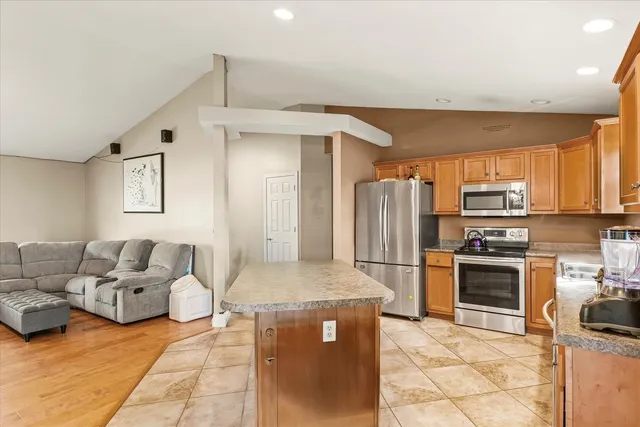 a kitchen with stainless steel appliances granite countertop a refrigerator and a stove top oven