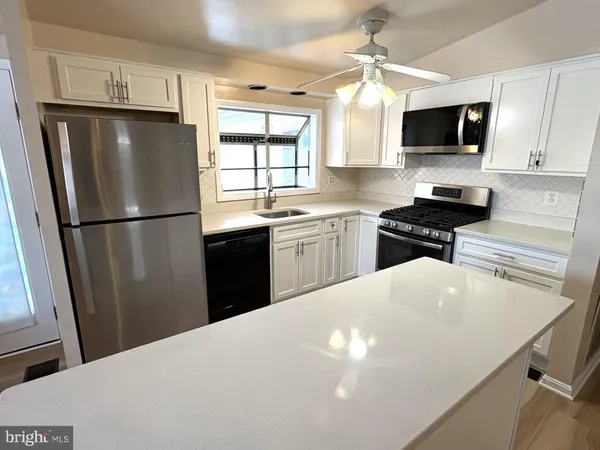 a kitchen with stainless steel appliances a refrigerator stove microwave and sink