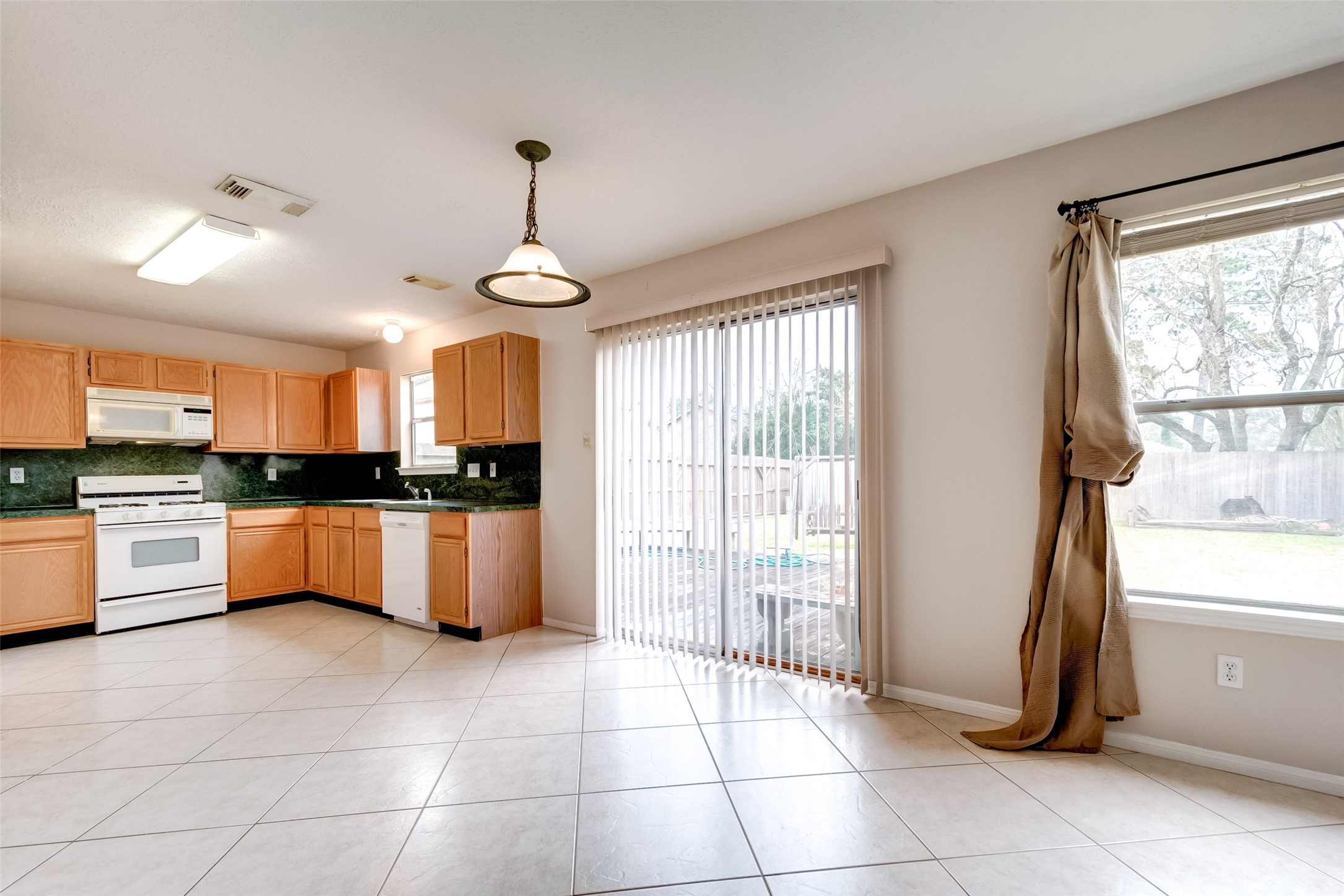 12654 Pine Bush Drive Houston, TX 77070 - Photo 7 of 35 a large kitchen with granite countertop a stove a sink and a refrigerator