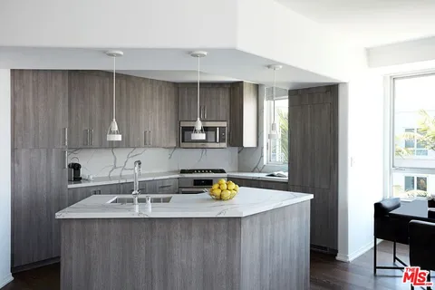 a kitchen with a sink a counter space and cabinets