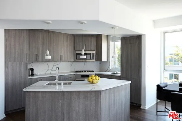 a kitchen with a sink a counter space and cabinets
